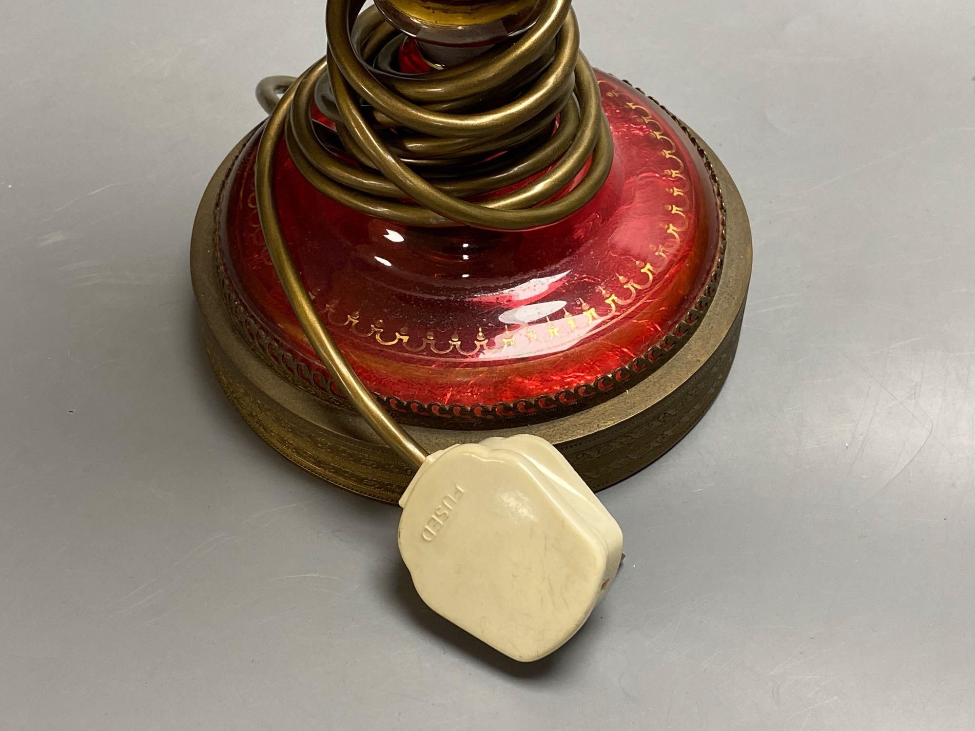 A 19th century Bohemian overlay ruby glass lamp, on engraved brass plinth, 34cm excluding light fittings